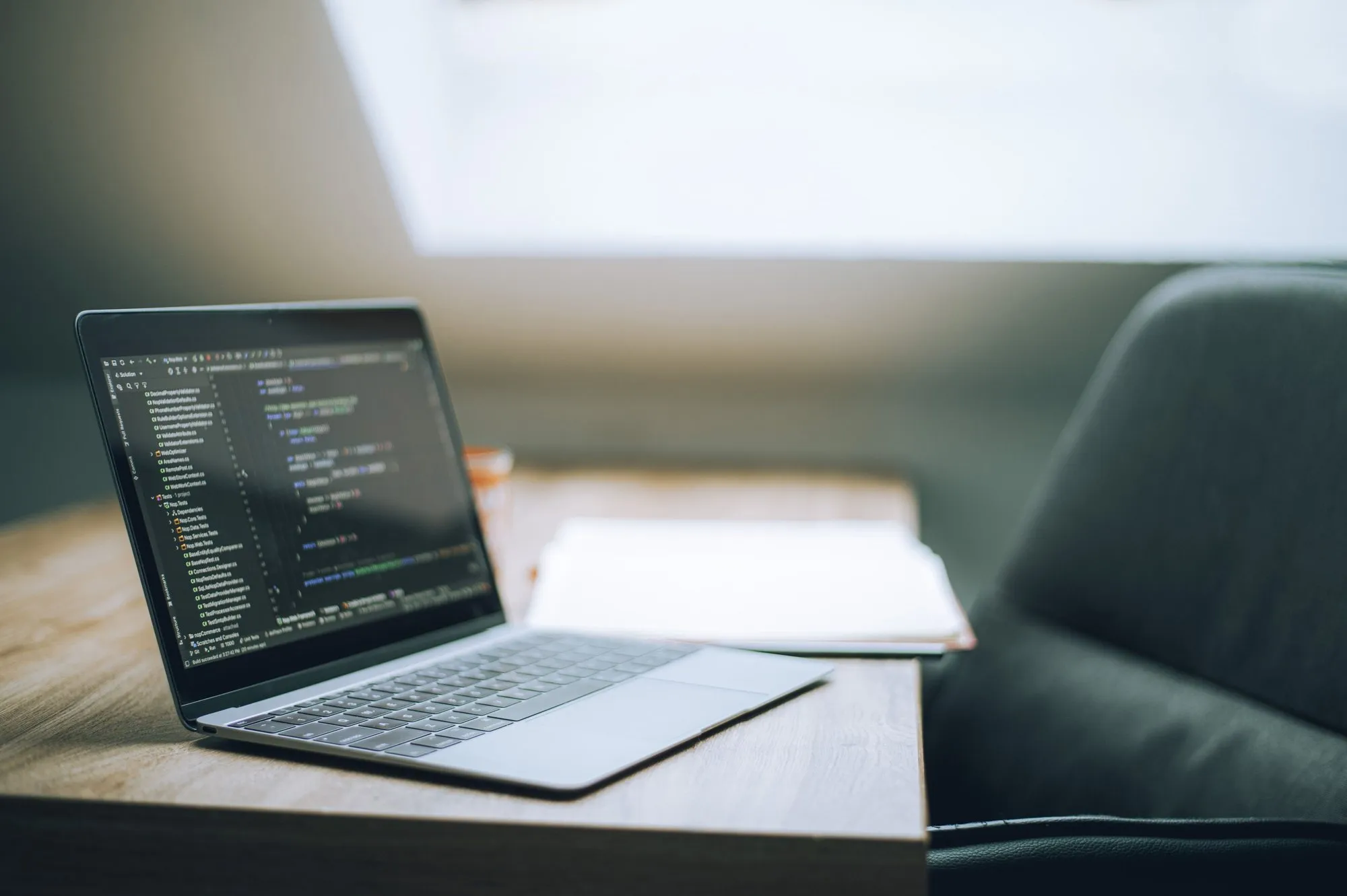 A laptop showing source code on a desk