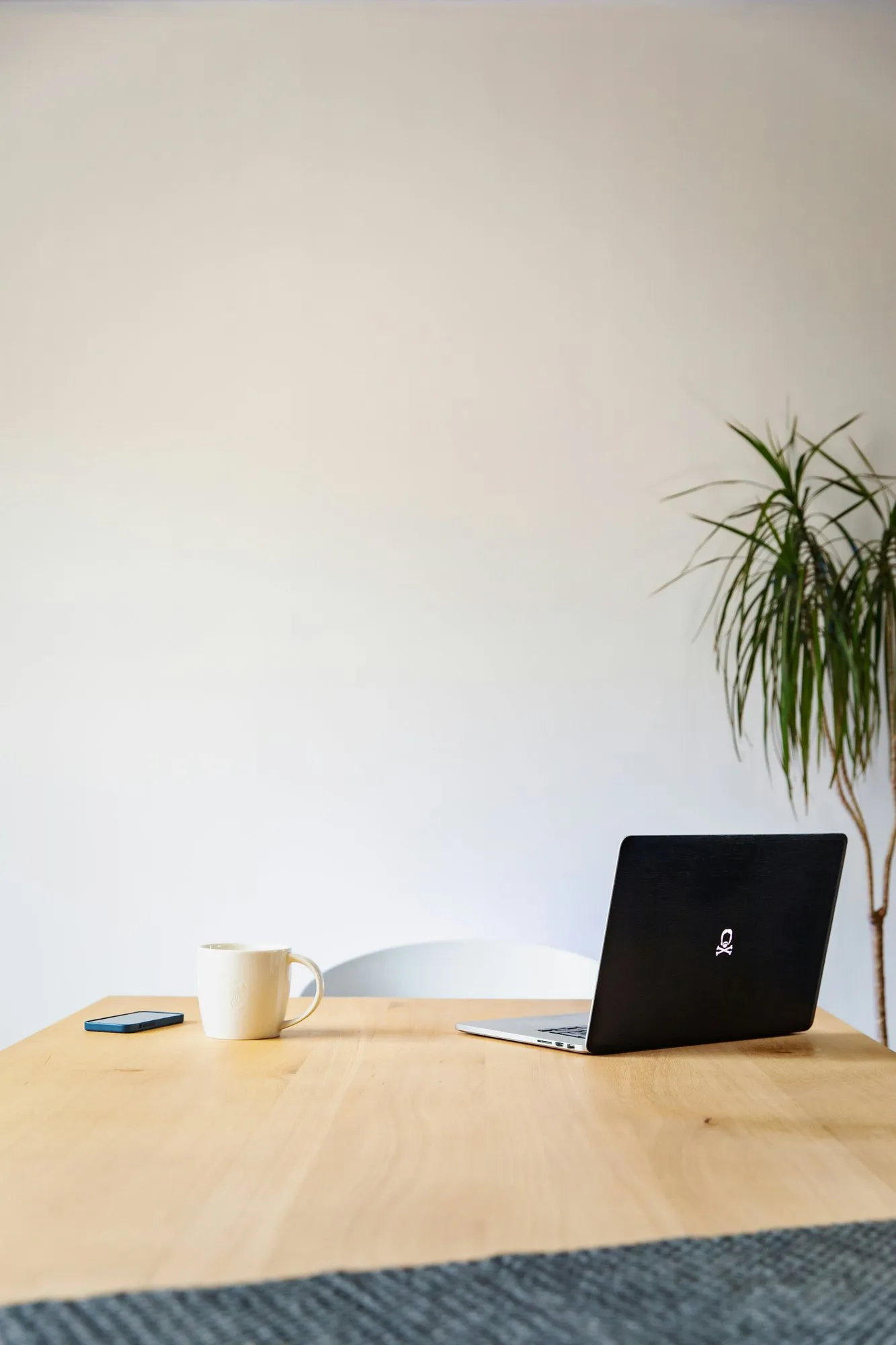 A laptop and a cup on a wooden desk